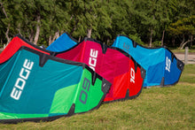 Load image into Gallery viewer, Four colorful kite surfboards with &#39;EDGE VT branding on a grassy area with trees in the background.

