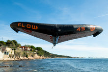 Load image into Gallery viewer, Large aircraft with 'FLOW' branding flying over a coastal area. ozone Flow v2 branding on a wingfoil portugal
